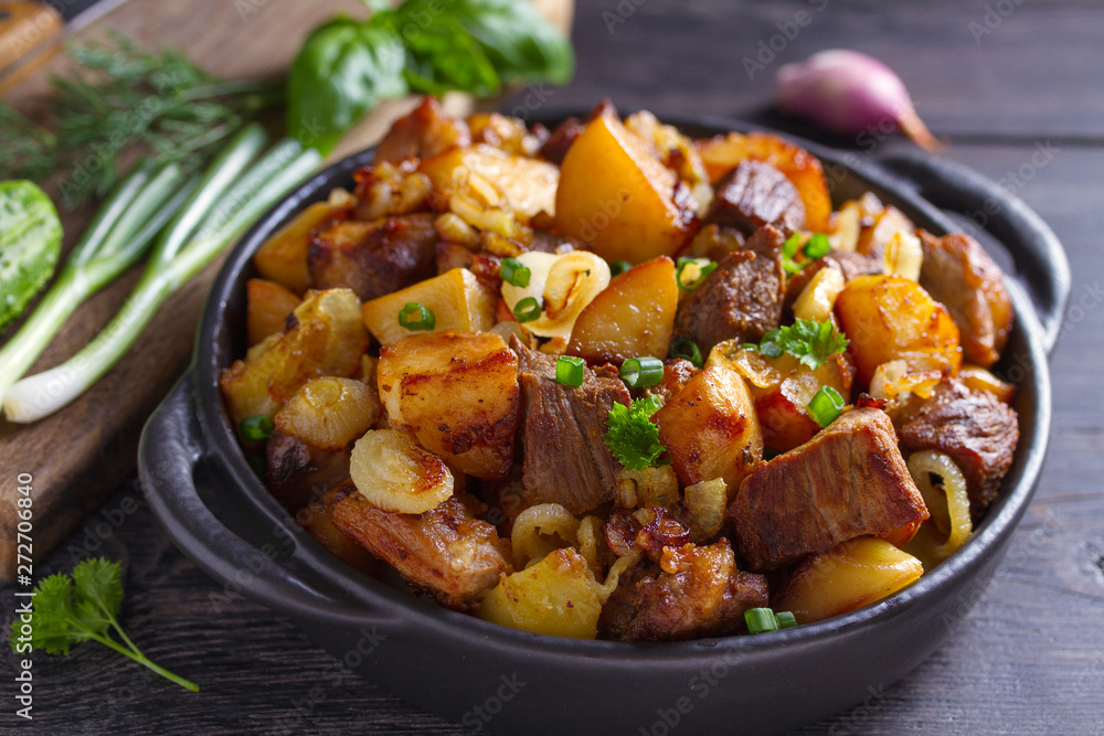 Tasty food: succulent beef with fried potatoes, onion and garlic. Country-style roasted potatoes with meat Tasty food: succulent beef with fried potatoes, onion and garlic. Country-style roasted potatoes with meat