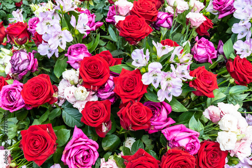 Strau   mit roten und dunkelrosa Rosen mit kleinen Lilien