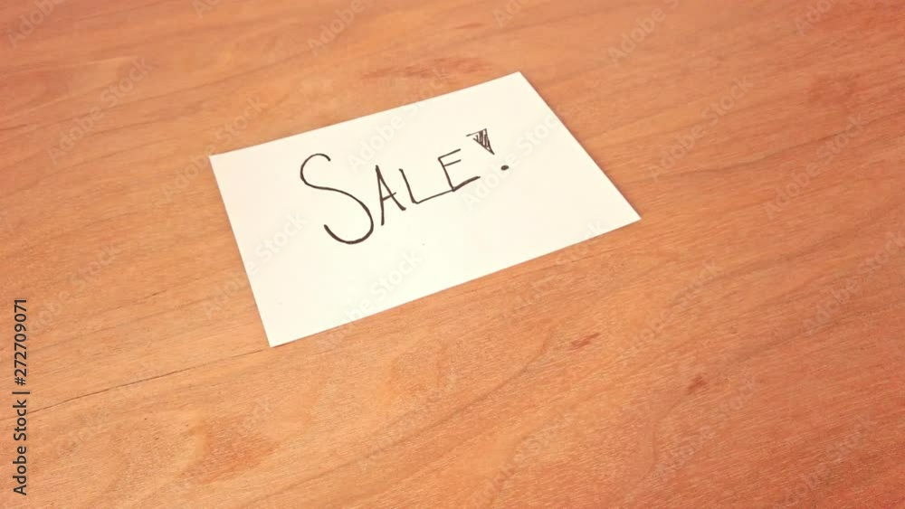 Memo post saying Sale lying on a wooden table. Smooth and stabilized dolly shot turning around handwritten message for shoppers. Memo post saying Sale lying on a wooden table. Smooth and stabilized dolly shot turning around handwritten message for shoppers.