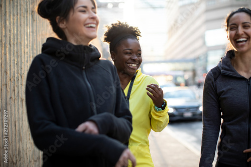 Φωτογραφία Happy female athletes talking while standing on sidewalk in city