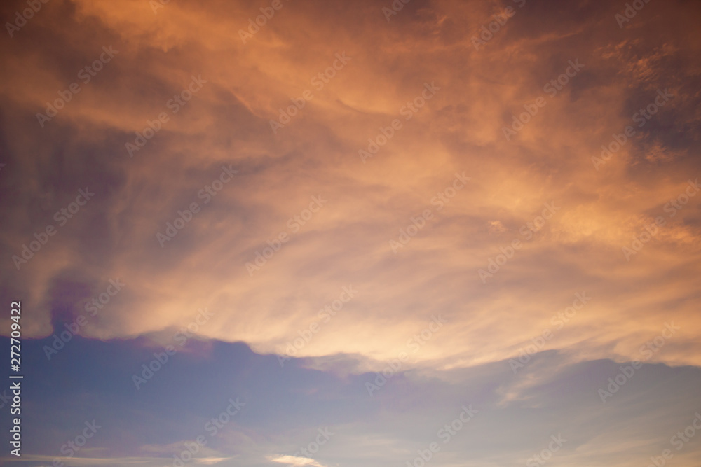 A BEAUTIFUL SUNSET SKY WITH ORANGE AND YELLOW CLOUDS WITH BLUE SKY