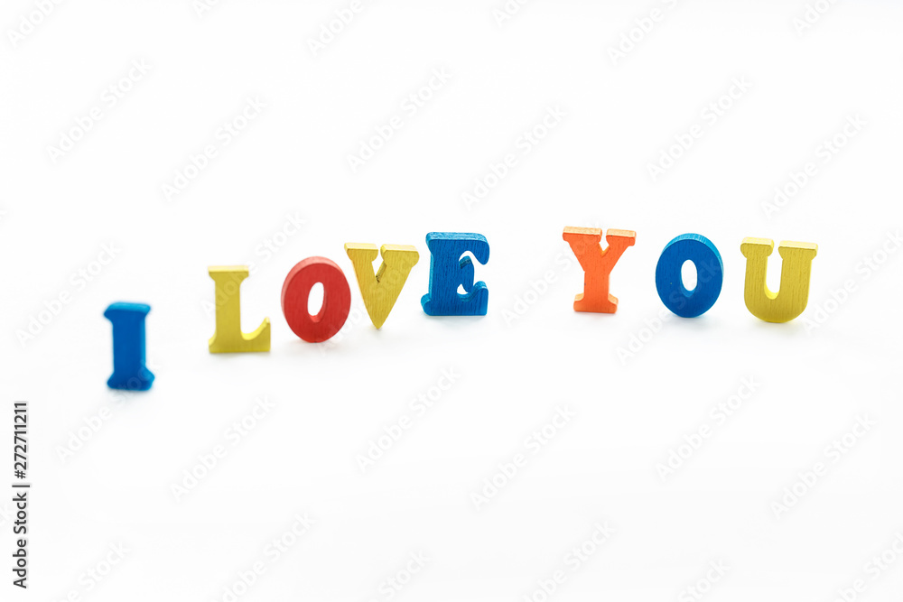 A Declaration of love consists of colored wooden letters standing on a white background. Love, isolate