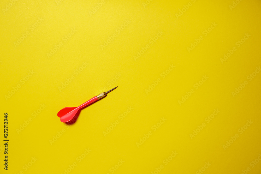 Single red arrow dart isolated on yellow background Single red arrow dart isolated on yellow background