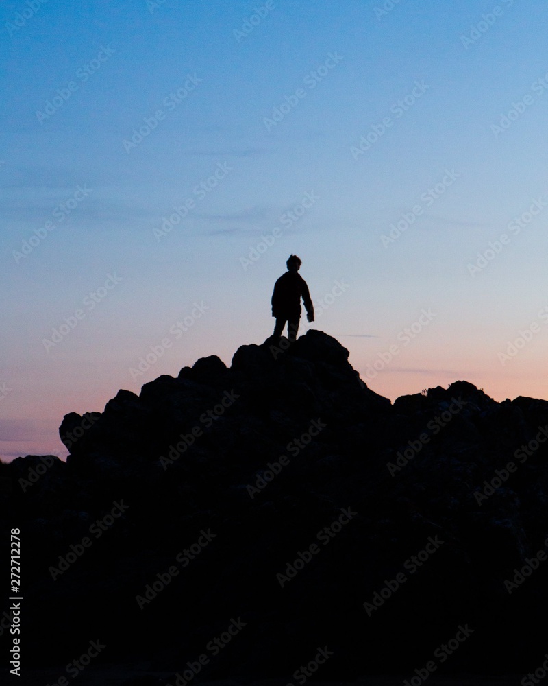 A silhouetted man upon a mountain 