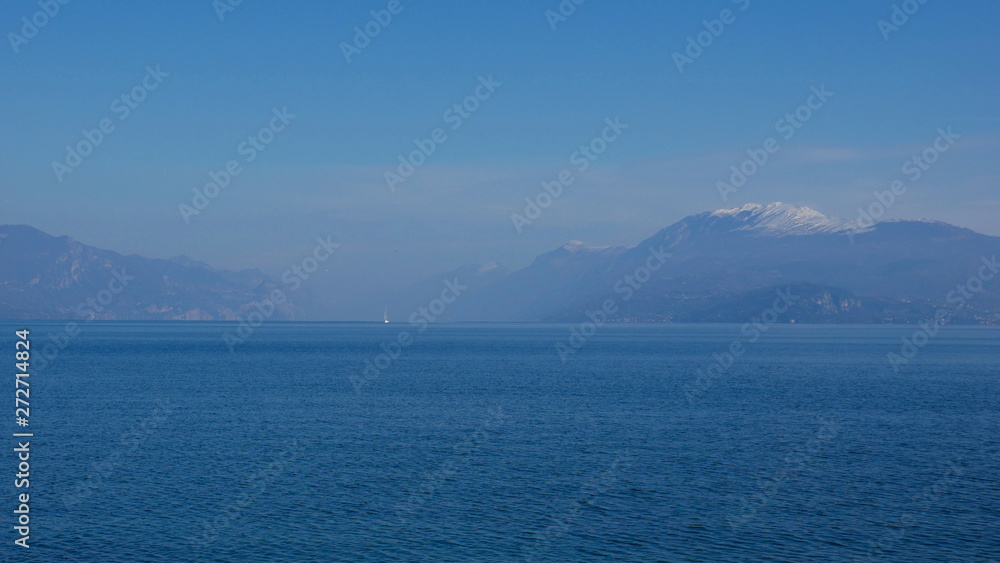 The blue waters of Lake Garda stretching up to the horizon. A popular destination for turistic trips to Italy. The blue waters of Lake Garda stretching up to the horizon. A popular destination for turistic trips to Italy.