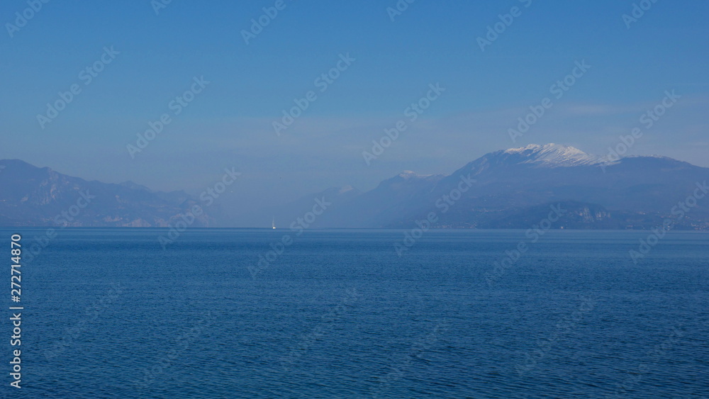 The blue waters of Lake Garda stretching up to the horizon. A popular destination for turistic trips to Italy.