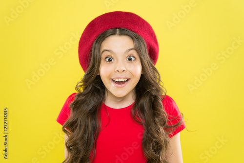 Perfect curls. Kid cute face with adorable curly hairstyle wear beret hat. Little fashionista. Little girl grow long hair. Styling of curly hair. Hairdresser service. Kid girl long healthy shiny hair