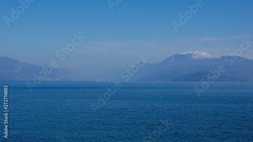 The blue waters of Lake Garda stretching up to the horizon. A popular destination for turistic trips to Italy.