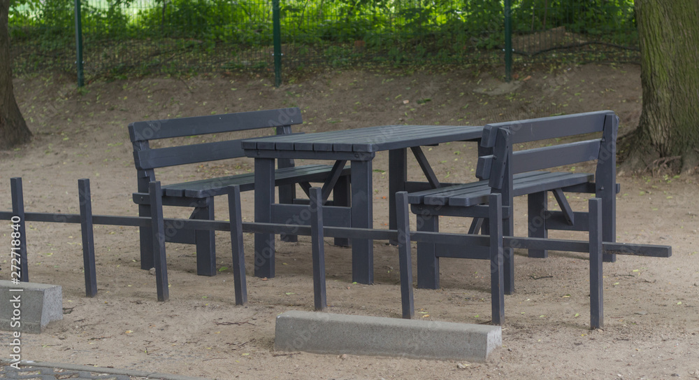 Black wooden table and benches in a park in Gdansk Oliwa, Poland