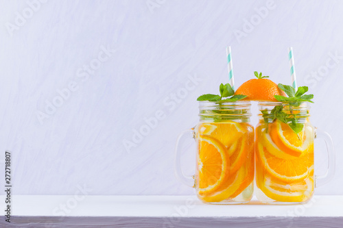Infused water with fruits on white background. Mug delicious refreshing drink of mix fruits with mint on white background. Iced summer drink in mason jar. Minimalism