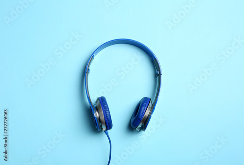 Stylish headphones on color background, top view