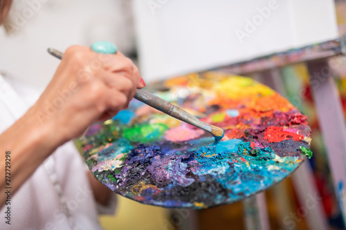 Woman holding painting brush and color palette