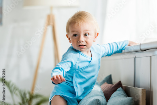 selective focus of cute toddler kid in modern bedroom