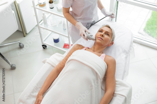 Serious mature woman receiving a dermadrop TDA procedure