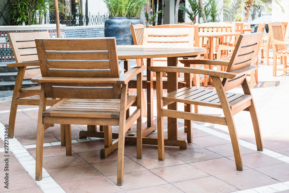 Set of wooden chairs and circular table in outdoor cafe at hotel area.