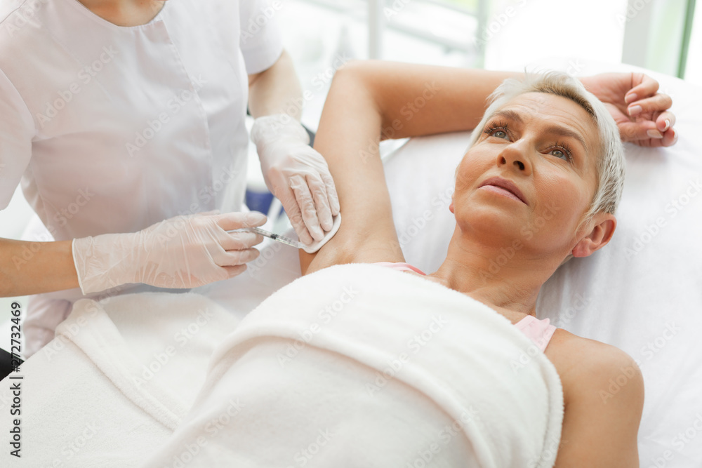 Obraz premium Nice aged woman holding her arm up