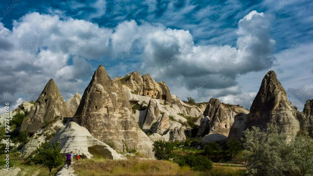 Cinemagraph of hikers frozen walking toward fairy chimneys of Urgup, Turkey and the sky is a time lapse. Cinemagraph of hikers frozen walking toward fairy chimneys of Urgup, Turkey and the sky is a time lapse.