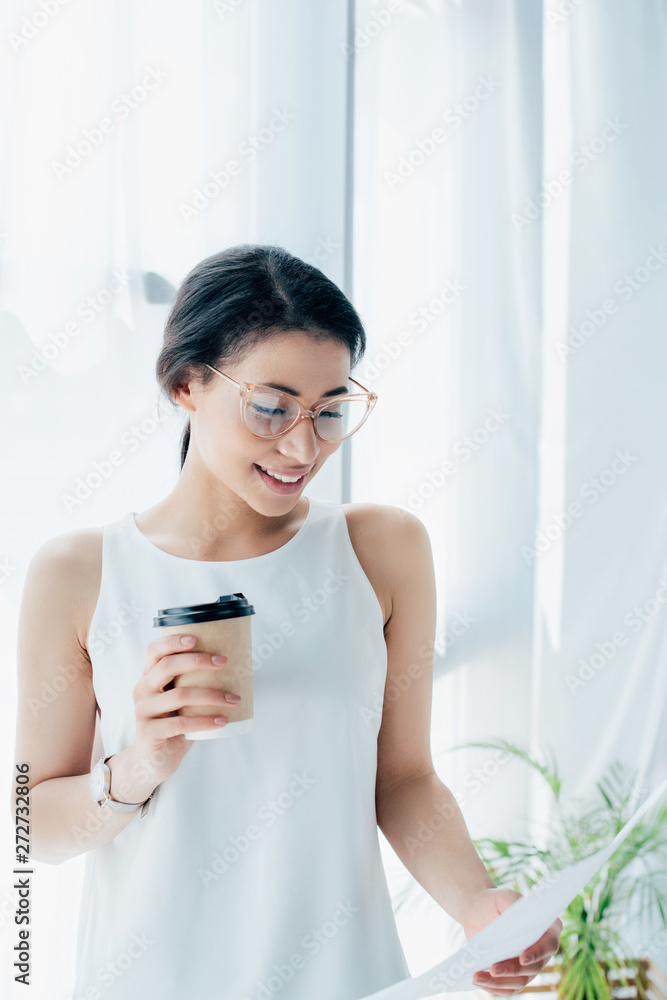 pretty latin businesswoman looking at paper while holding disposable cup pretty latin businesswoman looking at paper while holding disposable cup