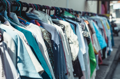 Εκτύπωση καμβά Selective focus and close up of many colorful of second hand clothes hanging on hanger in a row