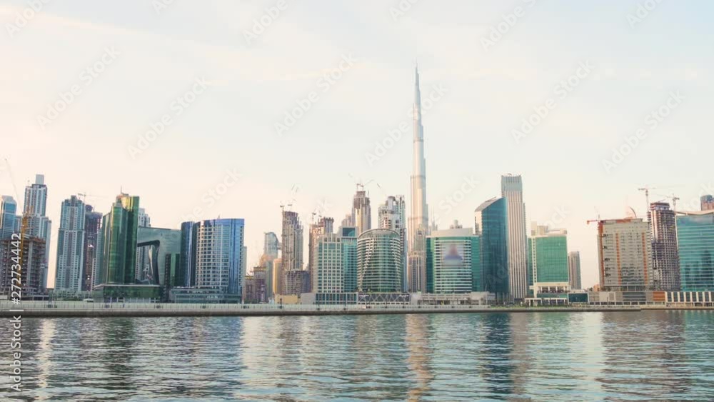Stunning view of the Dubai Skyline during a beautiful sunset with the Dubai water canal flowing in the foreground. Dubai, United Arab Emirates. Stunning view of the Dubai Skyline during a beautiful sunset with the Dubai water canal flowing in the foreground. Dubai, United Arab Emirates.