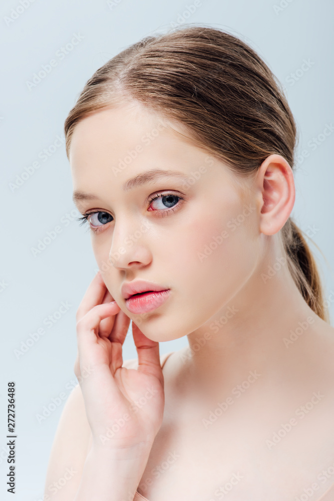 worried teenager looking at camera and touching face isolated on grey worried teenager looking at camera and touching face isolated on grey