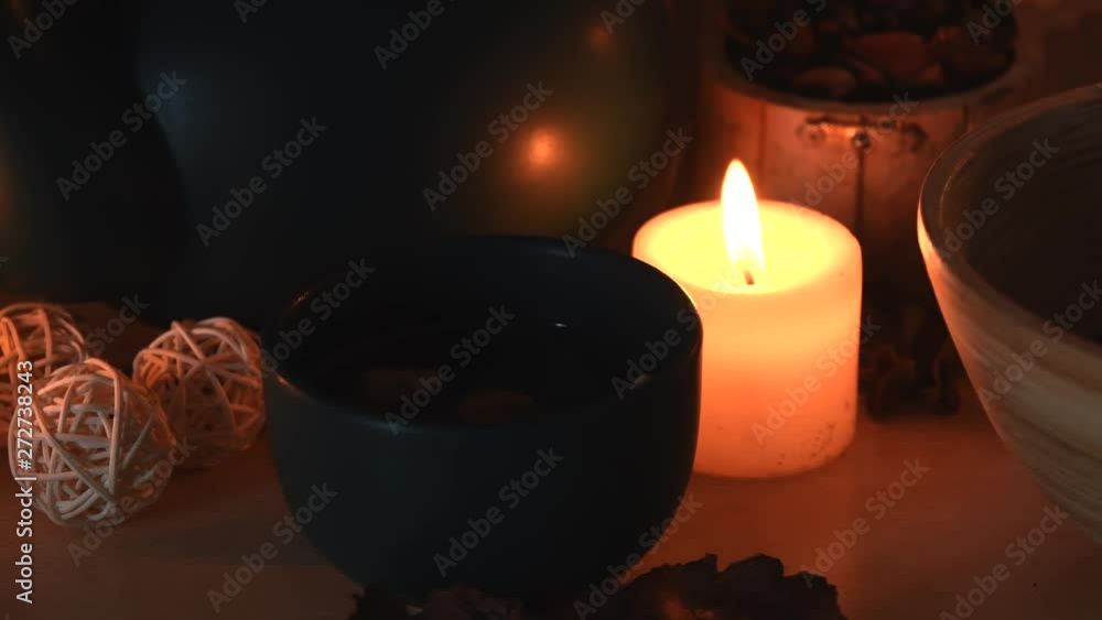 Relaxing background detail shot of an herbal tea shop, with candles with flickering flames, a tea pot, a cup with steam coming out and some herbs Relaxing background detail shot of an herbal tea shop, with candles with flickering flames, a tea pot, a cup with steam coming out and some herbs