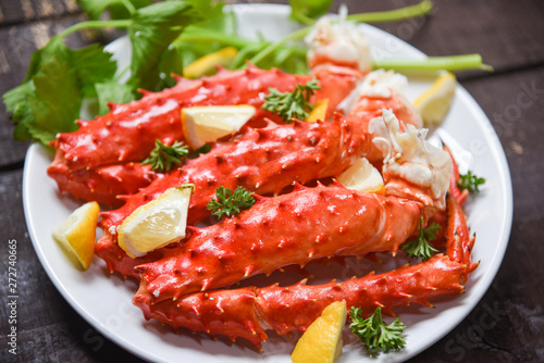 Alaskan King Crab Legs cooked seafood with lemon spices on white plate in the wooden table - red crab hokkaido