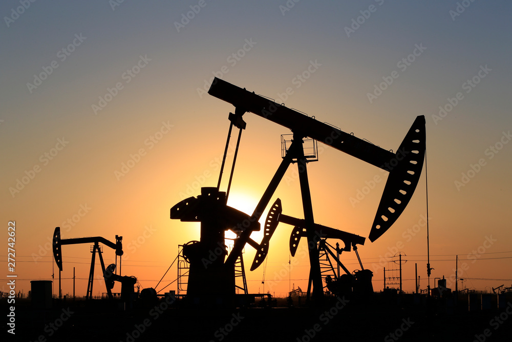 The pumping unit is working in the setting sun The pumping unit is working in the setting sun