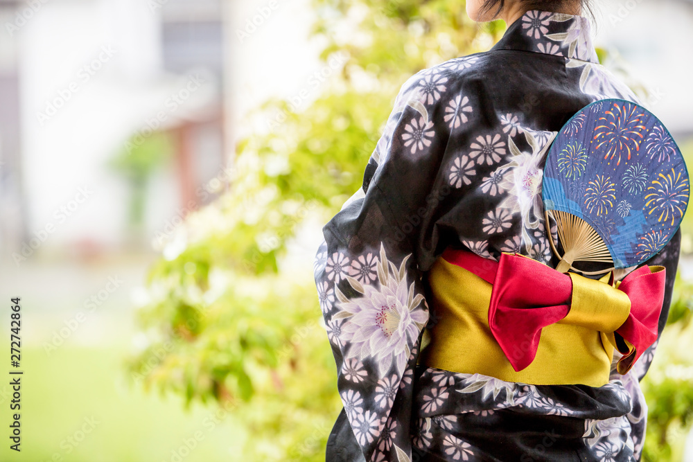 浴衣を着た30代のきれいな女性が緑の前に立って彼を待っている Stock Foto Adobe Stock