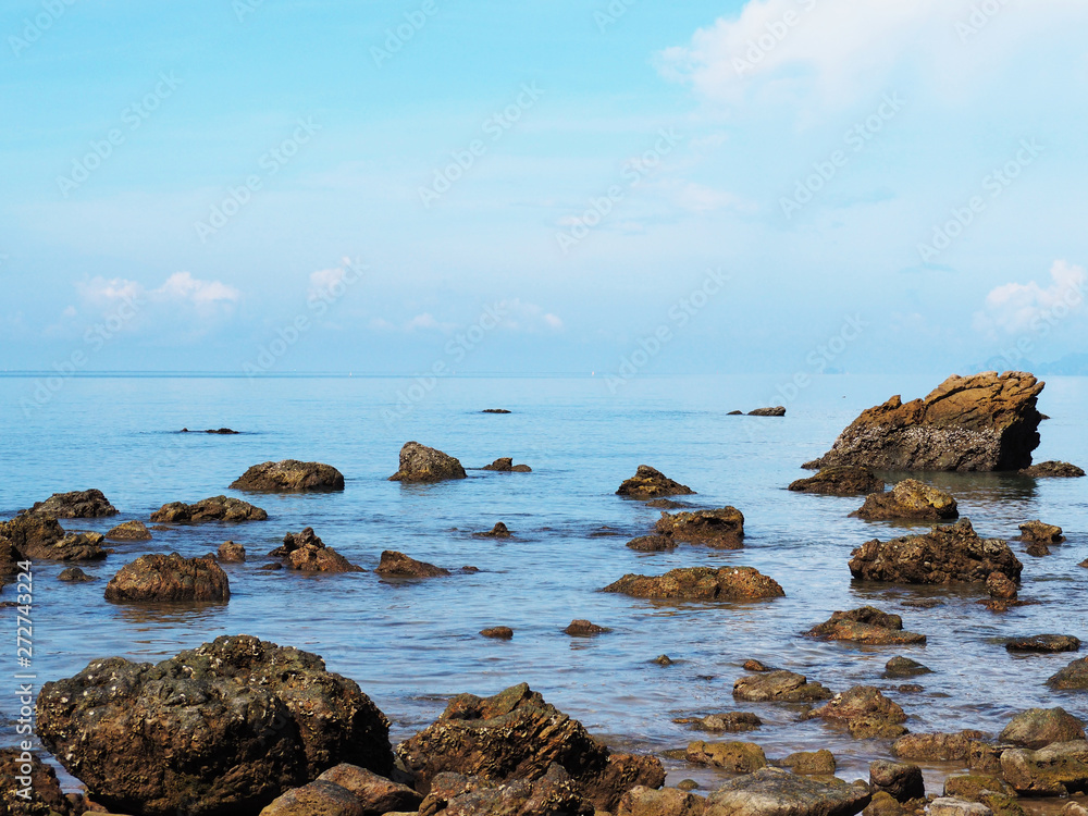 Close up rocks on summer sea and blue sky background.
