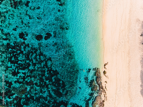 Aerial view of tropical beach and turquoise ocean.