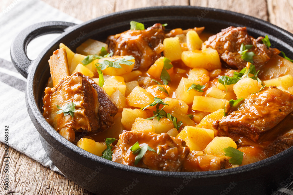 Homemade stew of short beef ribs with potatoes in a spicy sauce closeup in a pot. horizontal