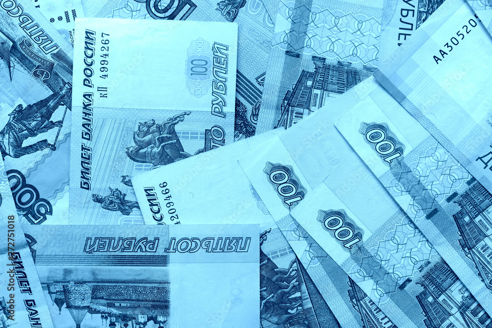 Fototapeta premium Different bills of Russian rubles close up. Money background blue color toned