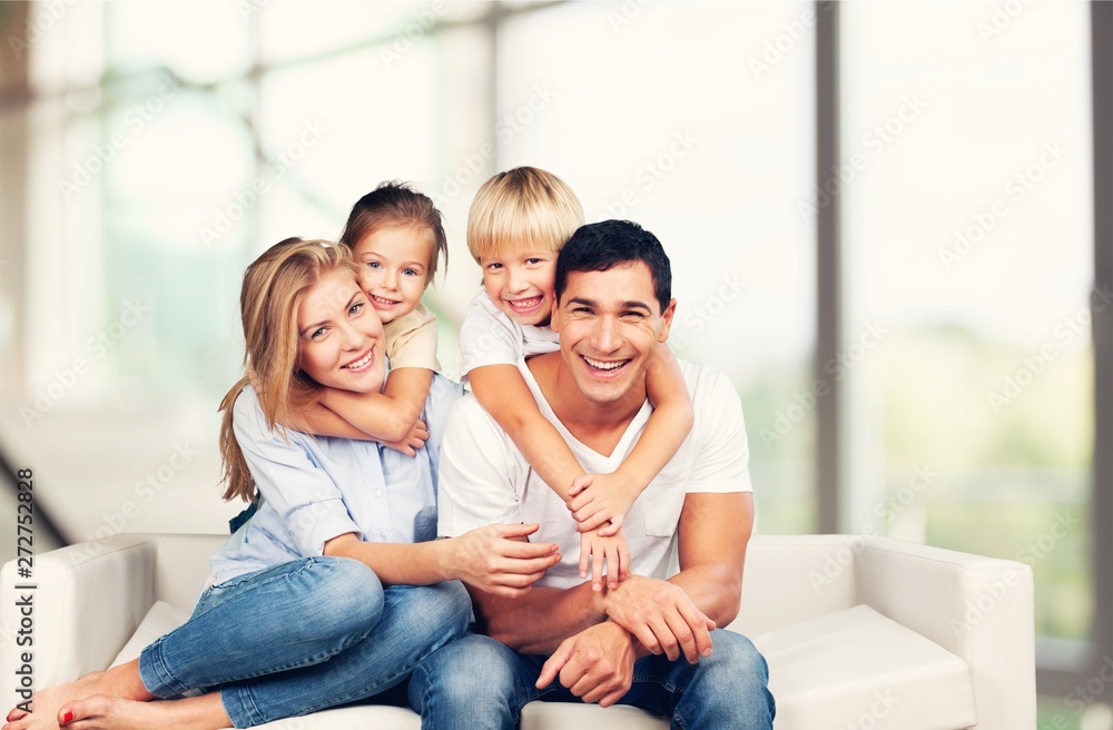 Beautiful smiling family sitting at sofa at home Beautiful smiling family sitting at sofa at home