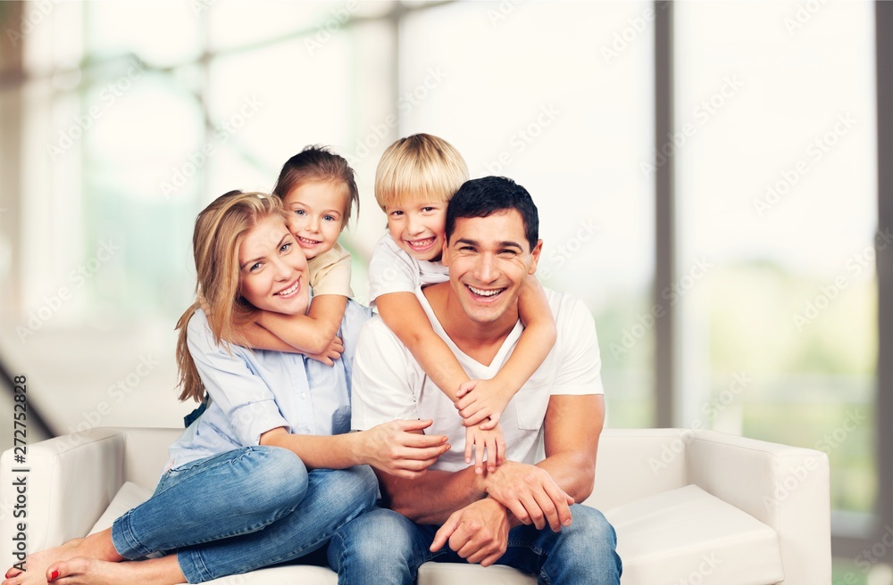 Beautiful smiling family sitting at sofa at home