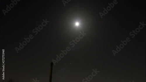 Timelapse of the moon with clouds on a starry night photo