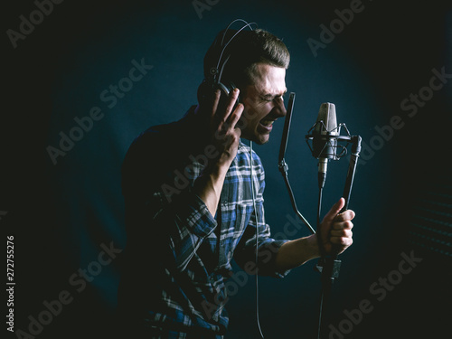 The young guy singing in recording studio