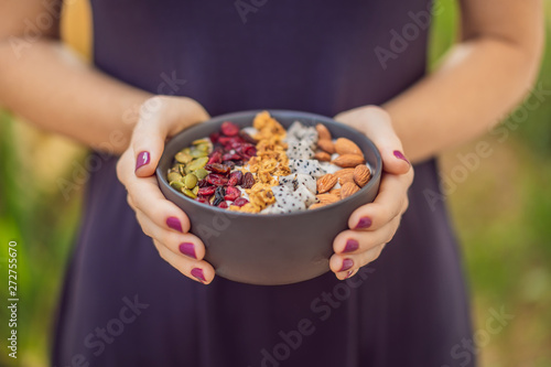 Women's hands are preparing a smoothie bowl photo