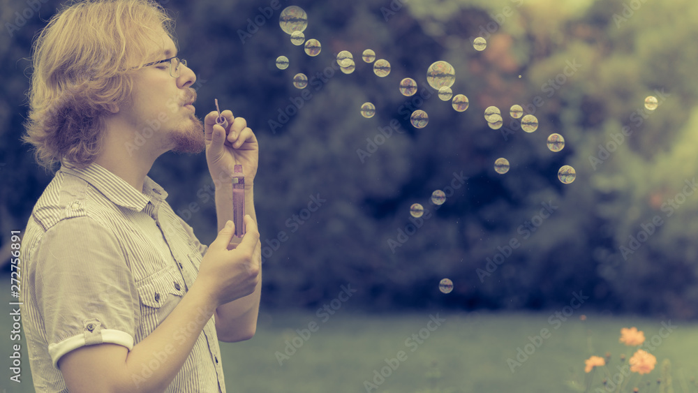 man blowing soap bubbles, having fun man blowing soap bubbles, having fun