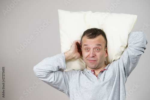 Man sleepy tired with pillow on grey