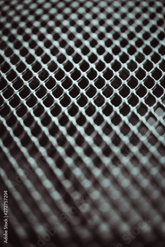 Metal background. Lattice texture with small cells grid. Selective focus point.