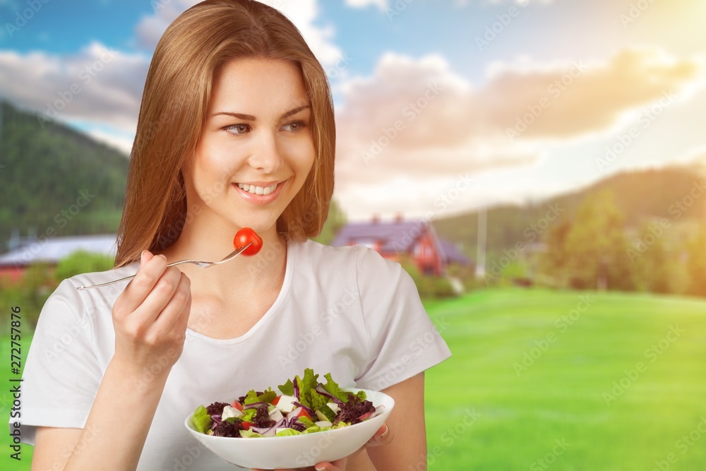 Attractive caucasian woman with salad  on background