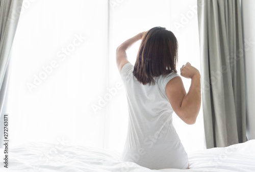 Wallpaper Mural Close up woman sitting on the bed and stretching after waking up for relax in the morning with over light background Torontodigital.ca