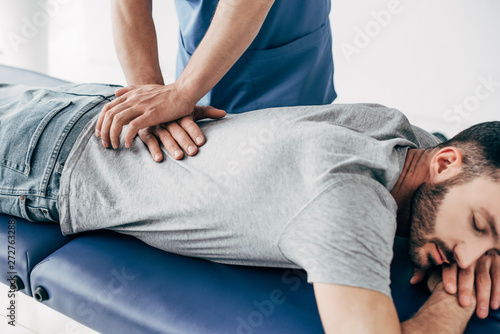 chiropractor massaging back of man on Massage Table in hospital photo