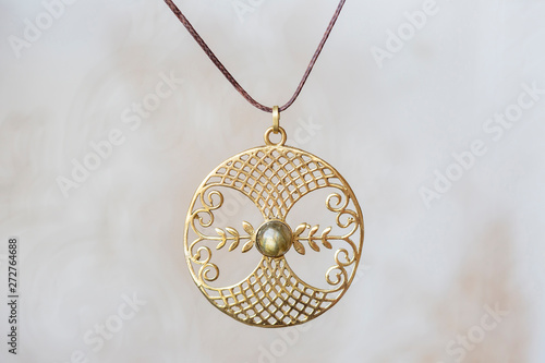 Brass metal labradorite stone pendant round mandala on neutral background