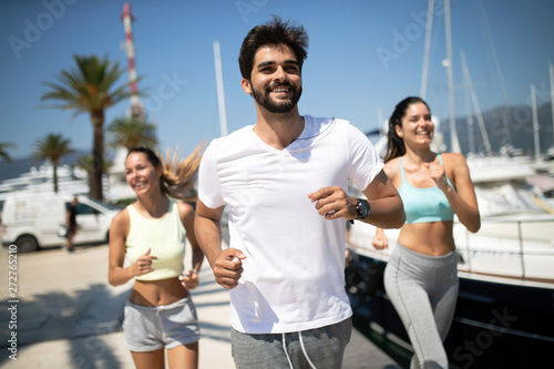 Happy fit people running and jogging together in summer sunny nature © NDABCREATIVITY