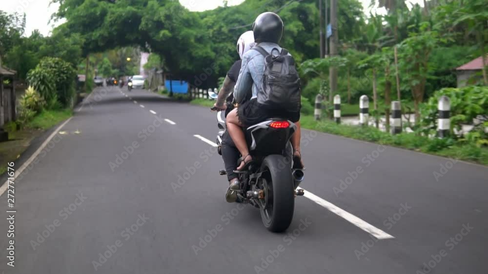 couple travelling on motorcycle through exotic country, guy drives, girl in back couple travelling on motorcycle through exotic country, guy drives, girl in back