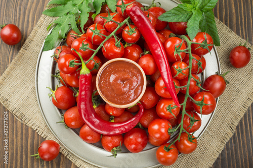 tomatoes lie on a silver plate of a bitter, tomatoes and chili peppers on them