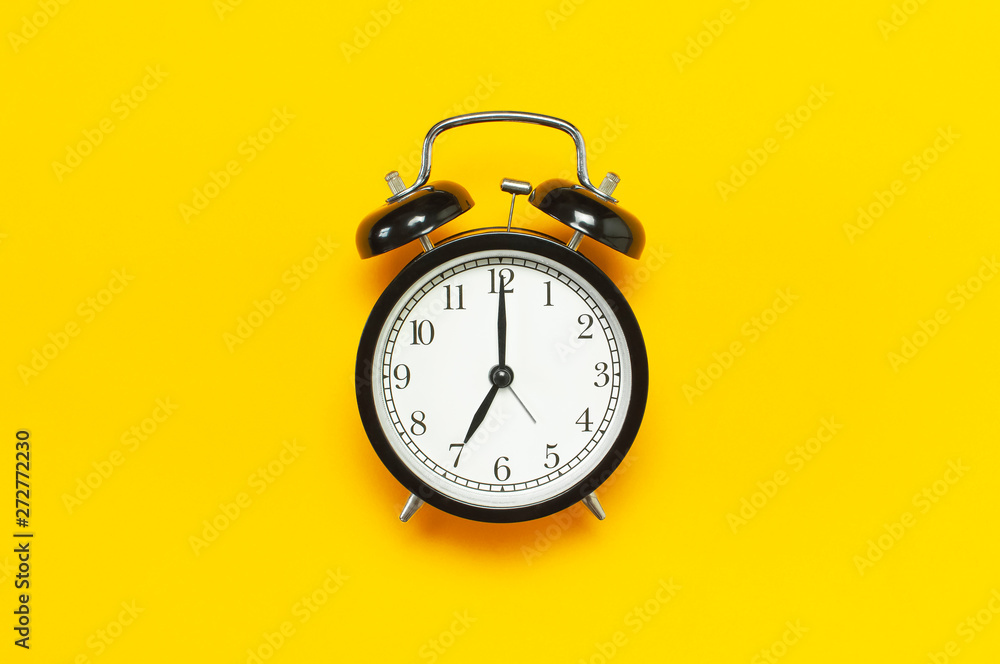 Black retro alarm clock on yellow background top view Flat lay copy space. Minimalistic background, concept of time, deadline, time to work, morning - obrazy, fototapety, plakaty 