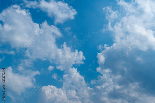 Blue sky in sunny day with white puffy clouds. Natural background